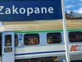 Niebieski znak "Zakopane" nad pociągiem PKP Intercity z numerem wagonu 2.