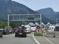 Korki na autostradzie przed punktem poboru opłat z widokiem na góry.
