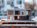Model nowoczesnego domu z betonowymi elementami i dużymi oknami. Widać schody zewnętrzne i taras. To wizualizacja, która pomoże oszacować koszt adaptacji projektu.