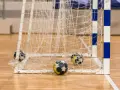 Piłki do piłki ręcznej leżą przy bramce. Poznaj zasady gry w piłkę ręczną i poczuj emocje sportowej rywalizacji!