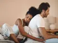 Un couple assis dos à dos sur un lit, l'air distant. On ne peut plus se parler sans s'engueuler.
