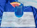 Przepis na Blue Lagoon: Błękitny drink z plasterkiem grejpfruta, ozdobiony niebieskimi gałązkami, na tle granatowej tkaniny.