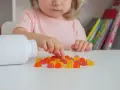 Dziecko wybiera żelki, które mogą być podawane jako żelazo noworodkowi.