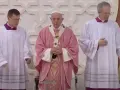 Pope Francis, in a pink vestment for the fourth Sunday of Lent, stands between two clergy members in white albs.