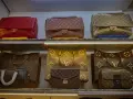 Borse Louis Vuitton fuori produzione, tra cui modelli classici e versioni con monogrammi iconici, esposte su scaffali illuminati.