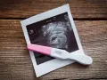 Test ciążowy i zdjęcie USG zapowiadają pierwsze trymestry ciąży.