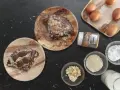 Pyszny keto omlet na słodko z kremem migdałowym, płatkami migdałów i cukrem pudrem. Obok składniki: jajka, mleko, mąka migdałowa, erytrytol.