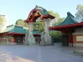 Eingang zum zoologischer garten mit asiatischer Architektur, Elefantenstatuen und grünen Dächern.