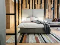 Przytulny pokój w hotelu butikowym. Co to? To miejsce z drewnianą ścianą, wygodnym łóżkiem i stylowym dywanem.