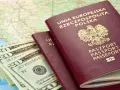 Dwa polskie paszporty, banknoty dolarowe i mapa. Czy do Rumunii potrzebny jest paszport? Tak, jeśli nie jesteś obywatelem UE.