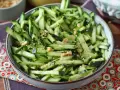 Una fresca insalata di cetrioli tagliati a julienne, condita con semi di sesamo, arachidi e peperoncino.