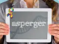 Kolorowa wstążka symbolizuje świadomość autyzmu. Na tablecie widnieje napis "asperger", a w tle grafika DNA, nawiązująca do objawów Aspergera.