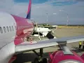 Samolot Wizz Air na płycie lotniska. Zastanawiasz się, co można zabrać do samolotu Wizzair? Sprawdź zasady przewoźnika przed podróżą.