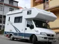 Biały kamper Fiat Ducato zaparkowany na ulicy. Zastanawiasz się, ile miejsc ma bus tego typu?