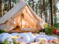 Przytulny namiot w lesie, idealny na glamping w Polsce. Wygodne łóżko, dekoracje i otoczenie natury tworzą magiczną atmosferę.