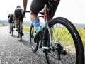 Cyclists on an endurance bike vs road bike race down a gravel road, showcasing their gear and determination.