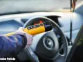 Policjant sprawdza, ile promili ma kierowca. Żółte światło na alkomacie sugeruje, że wynik jest poniżej dopuszczalnej normy.
