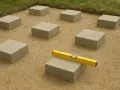 Układanie betonowych bloków pod przyszły taras. Poziomica na jednym z nich zapewnia równość.