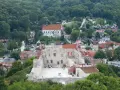 Ruiny zamku w Kazimierzu Dolnym na tle zielonych wzgórz i zabudowań.