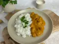 Pyszny Butter Chicken przepis na talerzu z ryżem i natką pietruszki. Idealny obiad.