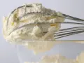 Puszysty krem z mascarpone, ubijany na drucianych trzepaczkach miksera, gotowy do deseru.