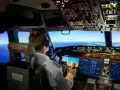 Pilota in cabina di pilotaggio, con schermi e comandi. Chissà quanto guadagna un pilota di aerei per gestire un volo così complesso.