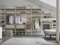 Un'idea per progettare cabina armadio: scaffali a vista con abiti appesi, cassetti e accessori.