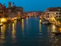 Serata magica per visitar Venezia: luci dorate sui palazzi e riflessi sull'acqua del Canal Grande, con gondole e ristoranti animati.