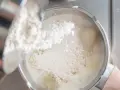 Wsypywanie mąki do płynu w garnku, aby zagęścić sos.
