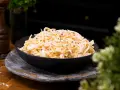 En skål med krämig, godaste coleslaw, toppad med peppar. Perfekt tillbehör!