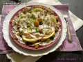 Carpaccio di polpo fresco, guarnito con olive, capperi e fette di limone, un piatto estivo da gustare.