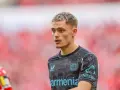 Młody piłkarz Florian Wirtz w koszulce Bayer Leverkusen, skupiony na boisku.