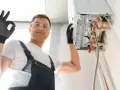 Installazione caldaia a condensazione risparmio energetico. L'installatore fa il segno OK.