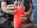 Man holding his foot, with a red area highlighting pain on the empeine del pie.