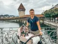Szczęśliwy ojciec z niemowlakiem w wózku na moście, idealne miejsce, gdzie na wakacje z niemowlakiem.