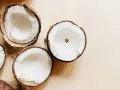 Plusieurs moitiés de noix de coco fraîches, révélant leur chair blanche et crémeuse. Un aperçu des bienfaits de l'huile de coco.
