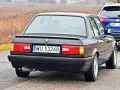 Tył czarnego BMW E30 z tablicą rejestracyjną WU 53268, holowanego przez niebieskiego SUV-a.