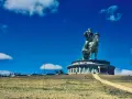 Statue équestre de Gengis Khan, symbole de la fortune et de la puissance de l'empire mongol, sous un ciel bleu éclatant.
