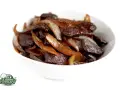 Un délicieux sauté de bœuf aux oignons caramélisés, servi dans un bol blanc. Un plat savoureux et réconfortant.
