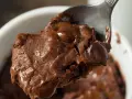 Łyżka z porcją pysznej, pieczonej owsianki brownie z roztopioną czekoladą.