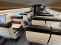 Interior of a modern train carriage, likely the Paris to Bilbao train, with rows of comfortable, beige and black seats.