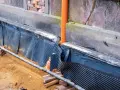 Prace przy starych fundamentach z kamienia: folia kubełkowa i drenaż to klucz do tego, jak wzmocnić stare fundamenty z kamienia.