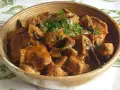 Un délicieux sauté de veau aux champignons, garni de persil frais, servi dans un bol en terre cuite.