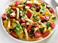 Bunter Nudelsalat ohne Mayo mit Penne, gegrilltem Gemüse wie Zucchini, Aubergine, Paprika, Kirschtomaten und frischem Basilikum, garniert mit Parmesan.