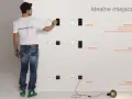 Mężczyzna pokazuje na jakiej wysokości gniazdka są idealne: 150 cm dla informacji, 110-120 cm dla akcji, 30 cm dla zasilania.