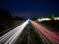 Nocne smugi świateł samochodów na autostradzie A4 między Katowicami a Krakowem. Opłaty za przejazd nie zatrzymują ruchu.