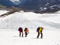 Drei Bergsteiger seilen sich über einen eisigen Gletscher in den Alpen ab.