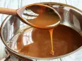 Caramelo líquido cayendo de una cuchara de madera a una olla, perfecto para tu flan al estilo Eva Arguiñano.