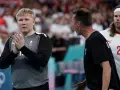 Trzech zawodników Danii w piłce ręcznej na boisku. Jeden z nich, w szarej koszulce, klaszcze.