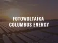 Ogromne pole paneli fotowoltaicznych o zachodzie słońca. Napis: Fotowoltaika Columbus Energy.